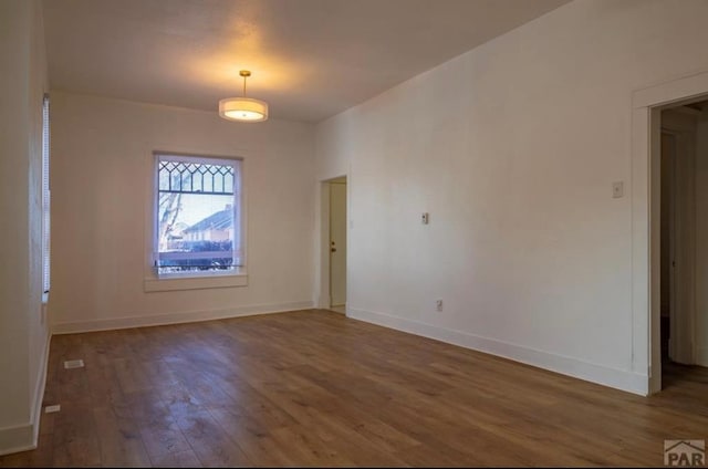 spare room with dark wood-style floors and baseboards