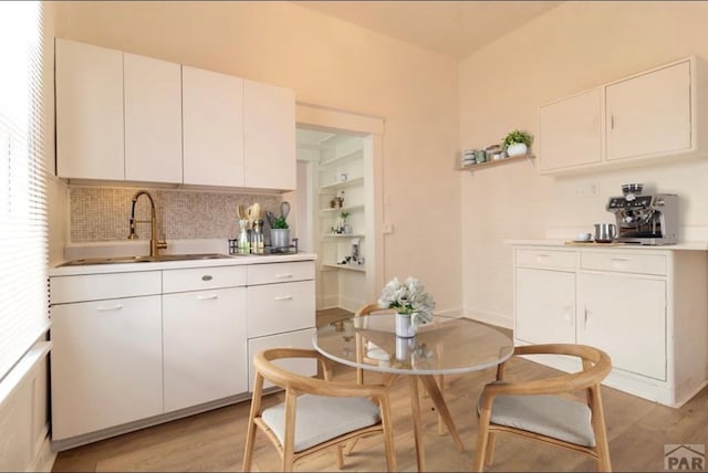 kitchen with light wood-type flooring, white cabinetry, and light countertops