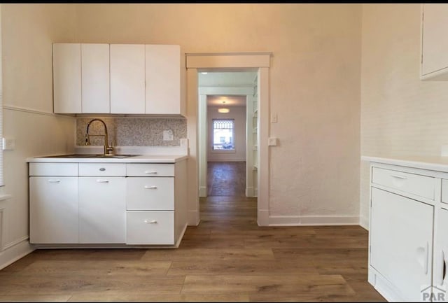 kitchen featuring white cabinetry, light countertops, and a sink