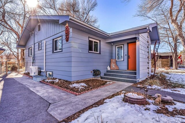 view of front of property featuring board and batten siding, entry steps, a gate, and fence