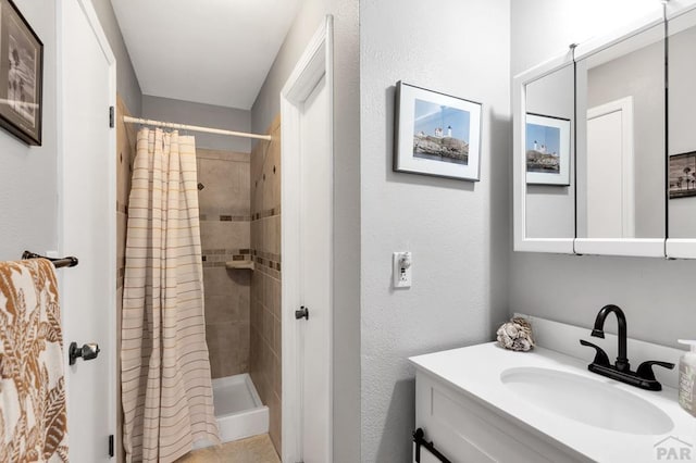 bathroom with a shower stall and vanity