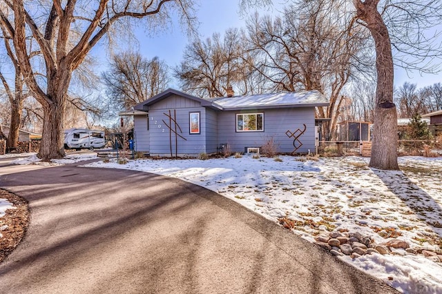 view of front of property featuring aphalt driveway and fence