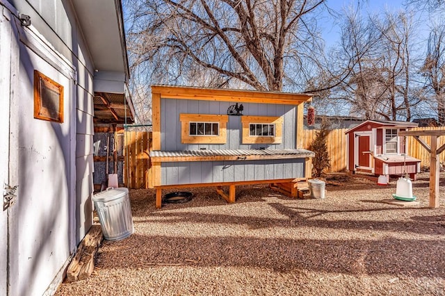 wooden deck featuring an outbuilding, a shed, and fence