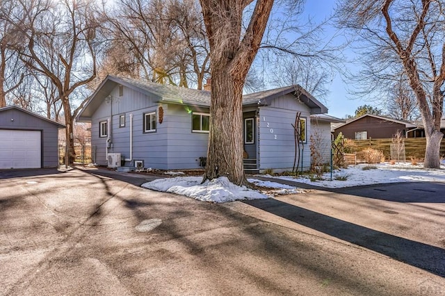 ranch-style home with driveway, ac unit, an outdoor structure, and a detached garage