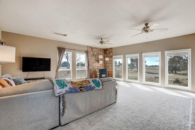 living room featuring carpet, visible vents, and a ceiling fan