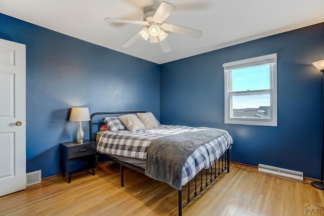 bedroom featuring visible vents, ceiling fan, baseboards, and wood finished floors