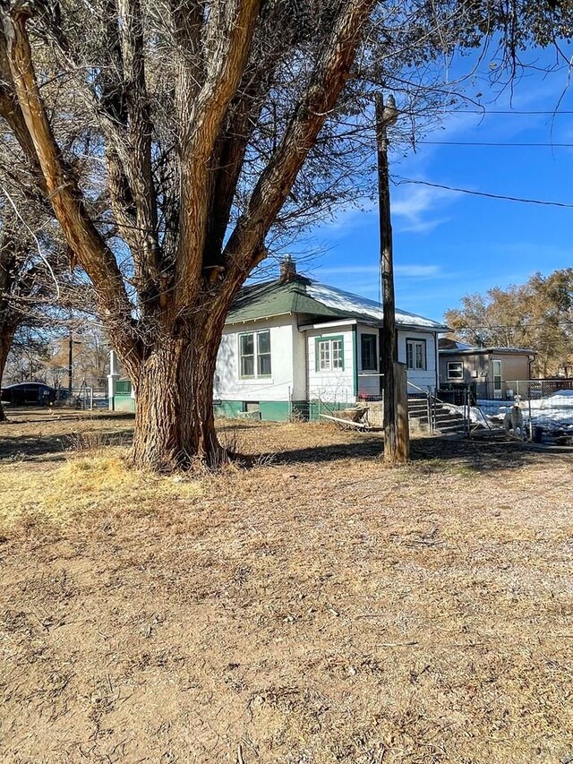 view of front facade with a chimney and fence