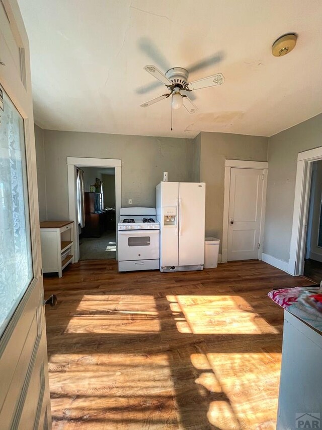 kitchen featuring light wood-type flooring, white appliances, ceiling fan, and baseboards