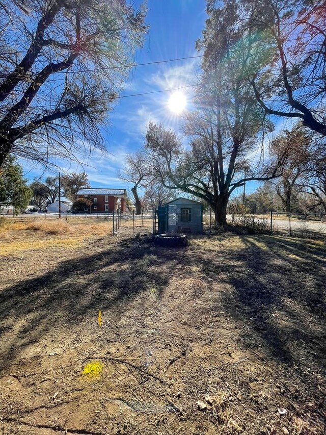 view of yard with an outbuilding, a rural view, and fence