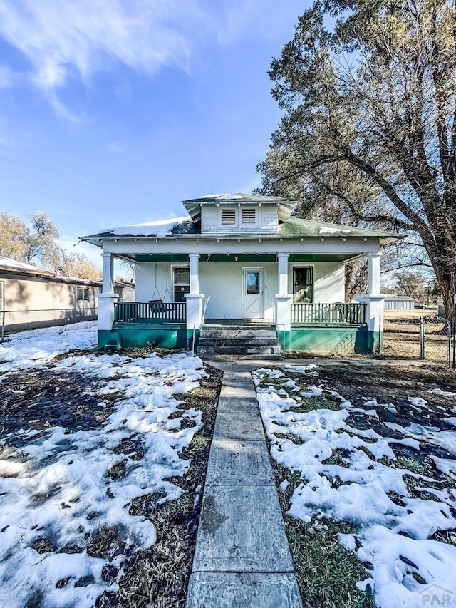 view of front of home featuring a porch and fence