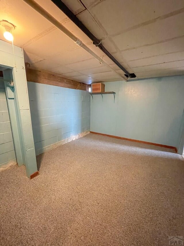 finished basement featuring concrete block wall and baseboards