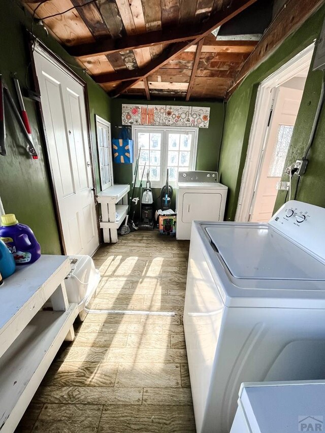 laundry room featuring washing machine and dryer, laundry area, wooden ceiling, and wood finished floors