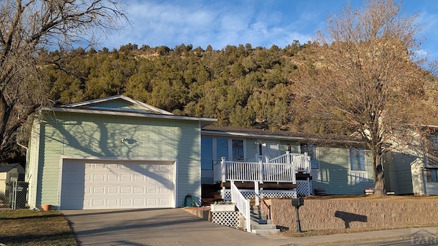 ranch-style house with a view of trees and concrete driveway