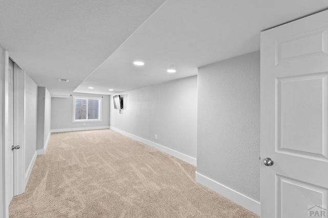 basement with recessed lighting, baseboards, and light colored carpet