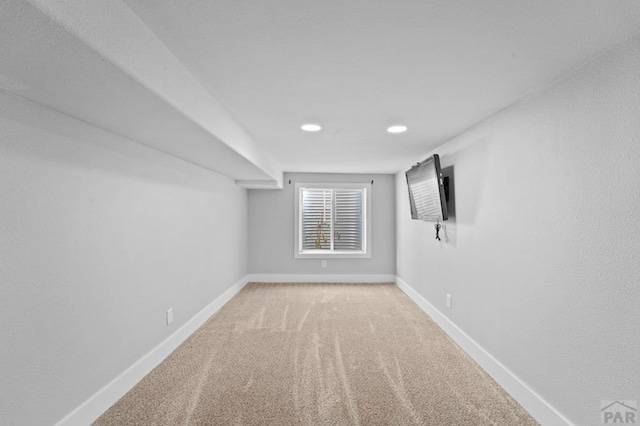 unfurnished room featuring baseboards and light colored carpet