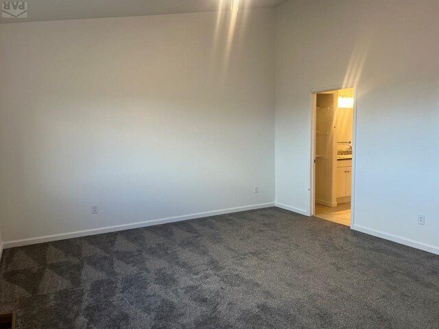 carpeted empty room featuring baseboards