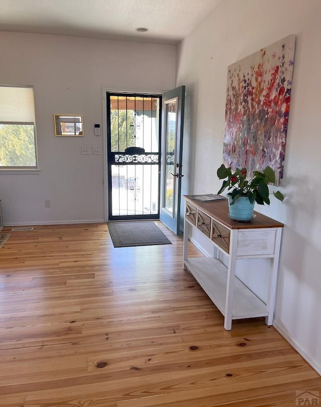 entryway with baseboards and light wood-style floors