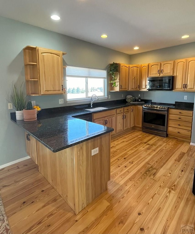 kitchen featuring black microwave, light wood-style flooring, a sink, stainless steel electric range, and open shelves