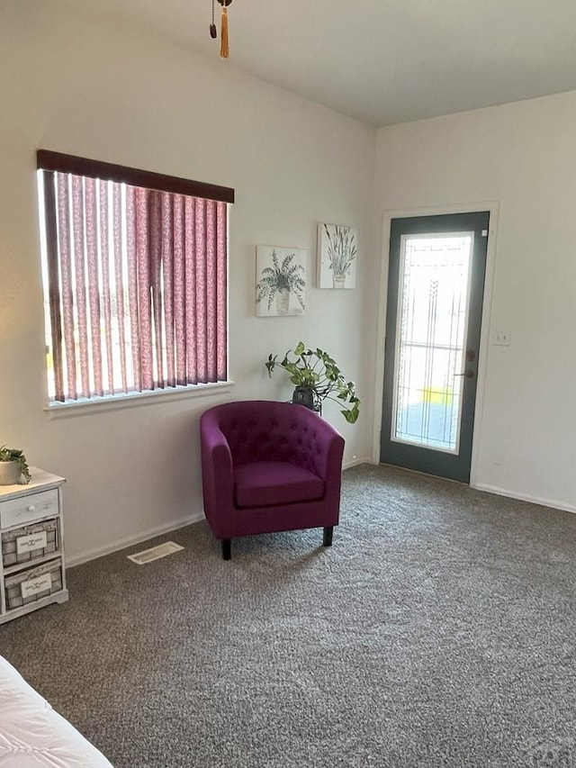 sitting room with baseboards, a healthy amount of sunlight, visible vents, and carpet flooring