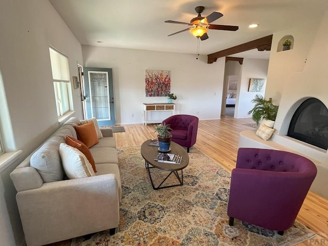 living area featuring a glass covered fireplace, ceiling fan, recessed lighting, and wood finished floors