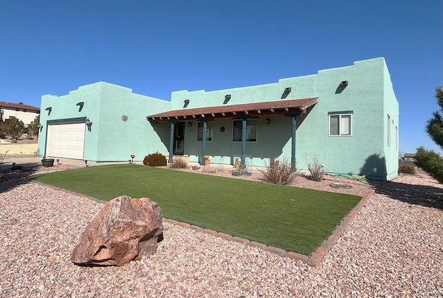 rear view of house featuring a porch, a lawn, an attached garage, and stucco siding