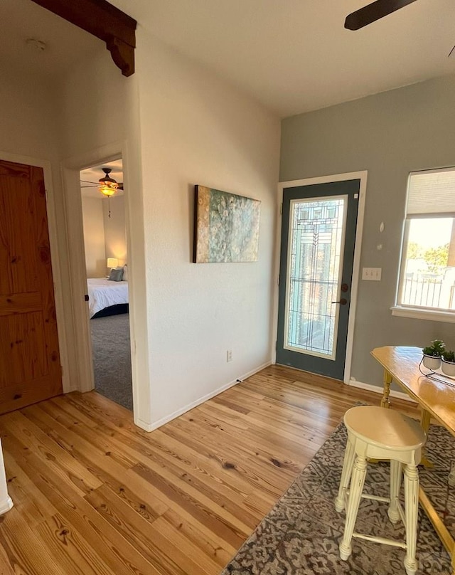 interior space featuring light wood-type flooring, ceiling fan, and baseboards