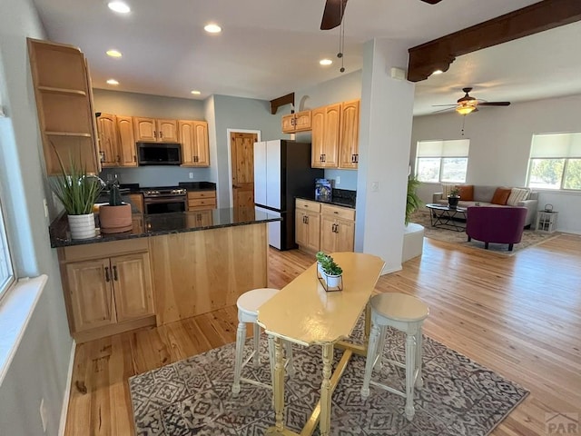 kitchen with gas range, freestanding refrigerator, light brown cabinetry, light wood-type flooring, and recessed lighting