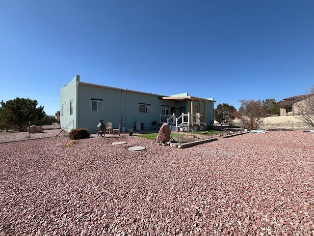 rear view of property featuring stucco siding