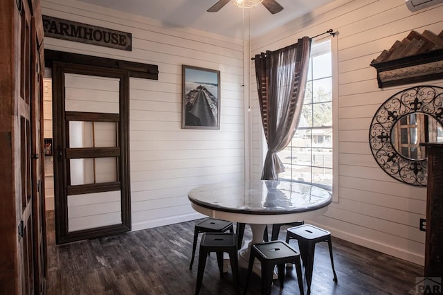 dining room featuring dark wood-type flooring, a wealth of natural light, and baseboards