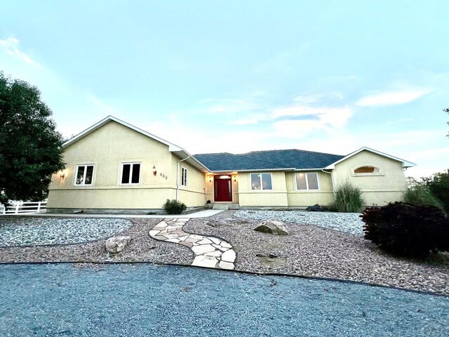 ranch-style home with fence and stucco siding