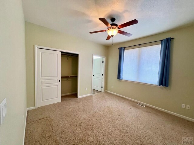 unfurnished bedroom with ceiling fan, visible vents, baseboards, a closet, and carpet