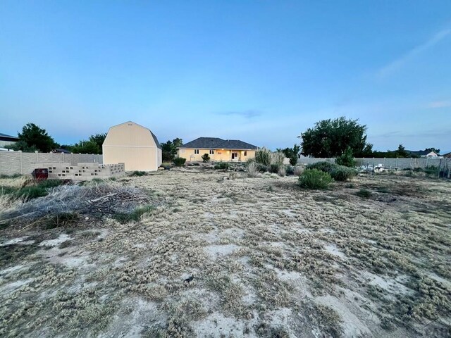 view of yard featuring a barn and fence