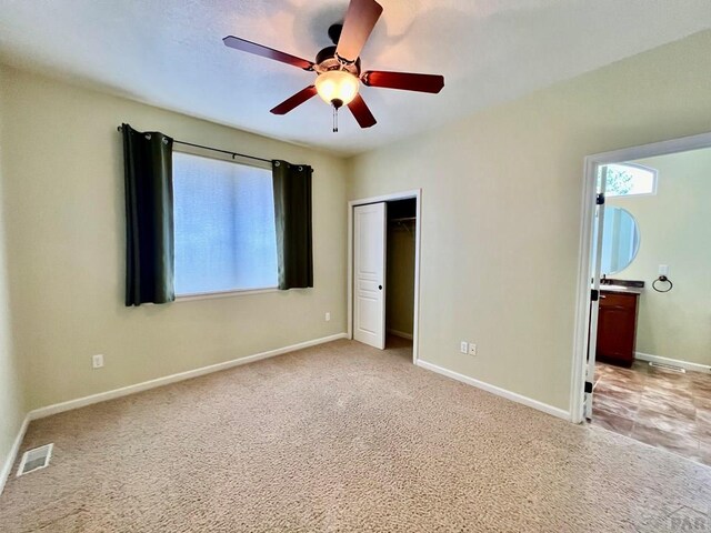 unfurnished bedroom featuring light carpet, a closet, visible vents, and baseboards