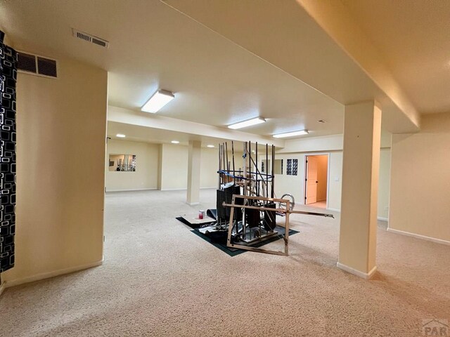 workout area with baseboards, visible vents, and light colored carpet