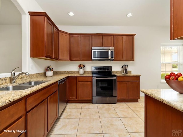 5522 Ventana Ct, Pueblo, CO 81005 - kitchen featuring stainless steel appliances, light stone countertops, light tile patterned floors, recessed lighting, and brown cabinetry