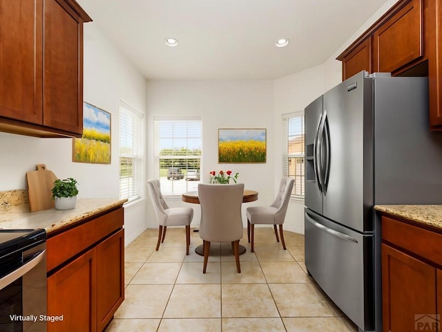 5522 Ventana Ct, Pueblo, CO 81005 - kitchen featuring stainless steel refrigerator with ice dispenser, recessed lighting, light tile patterned floors, range, and light stone countertops