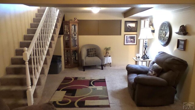 living room with stairs and light colored carpet