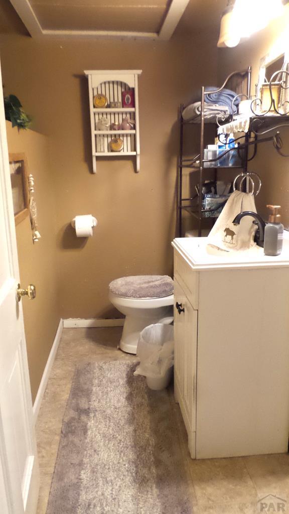 bathroom featuring baseboards, vanity, and toilet