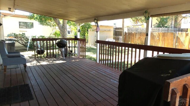 wooden deck with a grill and fence