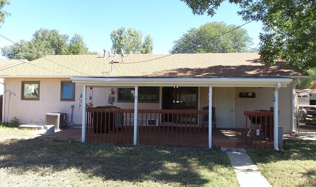 single story home featuring cooling unit, roof with shingles, a patio, and a front yard