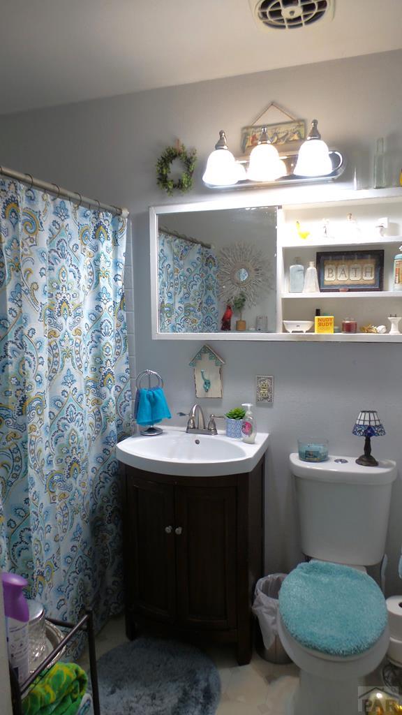 bathroom with visible vents, toilet, and vanity