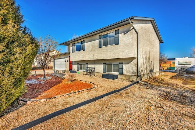 back of property with a garage and fence