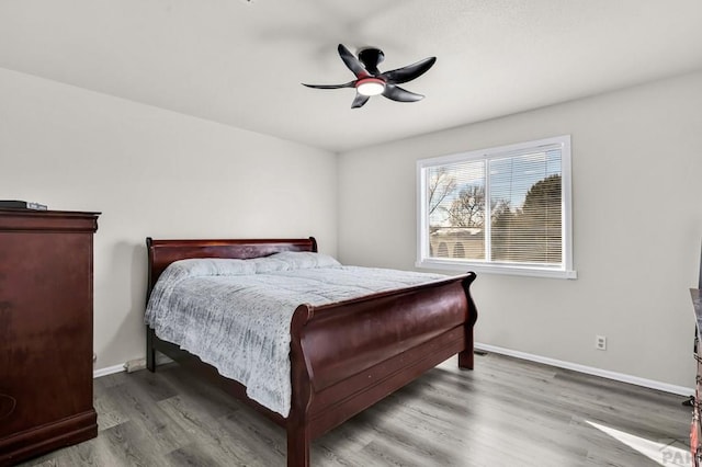 bedroom with a ceiling fan, baseboards, and wood finished floors