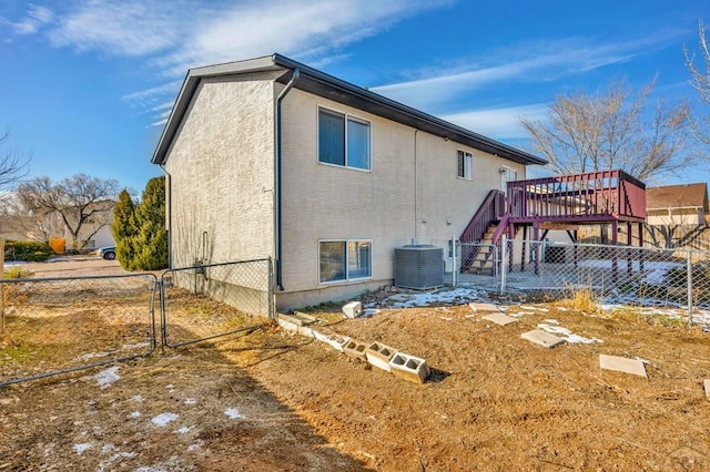 back of property featuring stucco siding, fence, a deck, cooling unit, and stairs