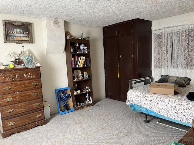 bedroom featuring a closet, a textured ceiling, and carpet