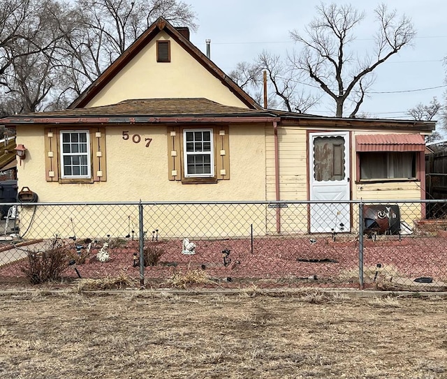 view of front facade featuring fence and stucco siding