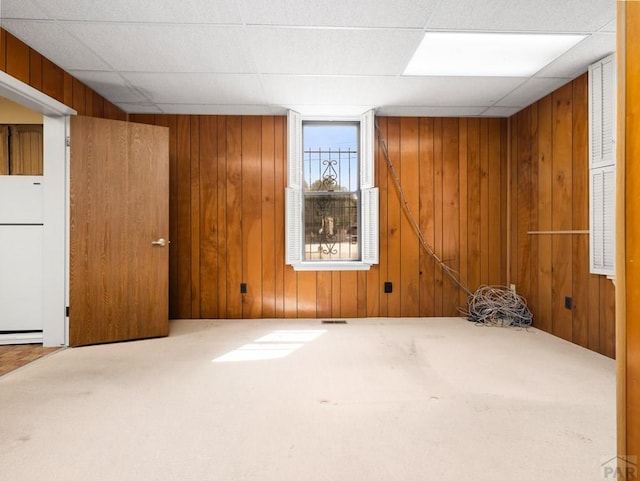 215 E Pitkin Ave, Pueblo, CO 81004 - basement featuring freestanding refrigerator, carpet flooring, wood walls, and a baseboard radiator