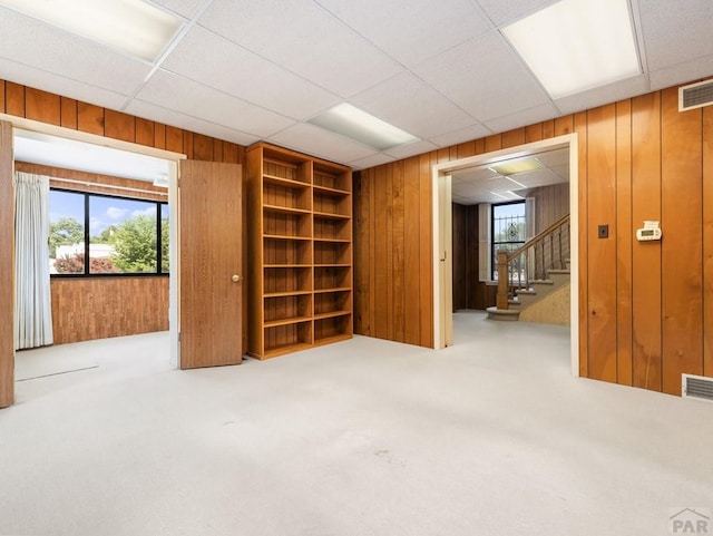 215 E Pitkin Ave, Pueblo, CO 81004 - carpeted empty room featuring wood walls and stairway