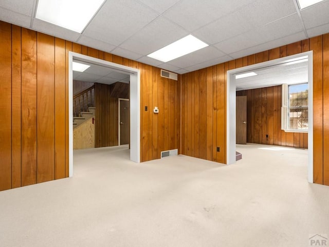 215 E Pitkin Ave, Pueblo, CO 81004 - spare room with wooden walls, stairway, carpet floors, and a paneled ceiling