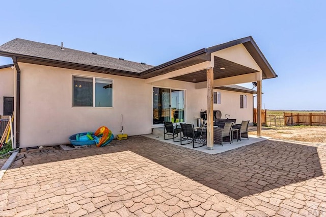 1207 N Jon Ln, Pueblo West, CO 81007 - back of house with stucco siding, a patio, and roof with shingles